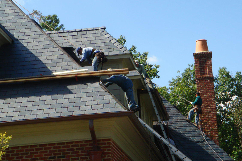 Someone working on a roof of a residential house