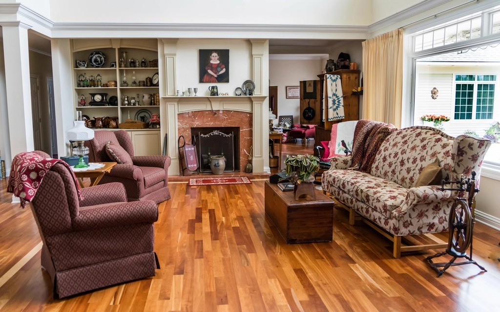 Cozy living room with burgundy armchairs, cream walls, wood floors and built-in shelves beside a fireplace