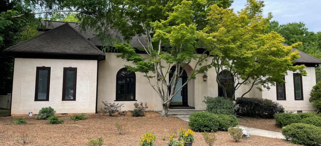 Stucco home exterior with dark trim in the Charlotte area, painted by SouthEnd Painting
