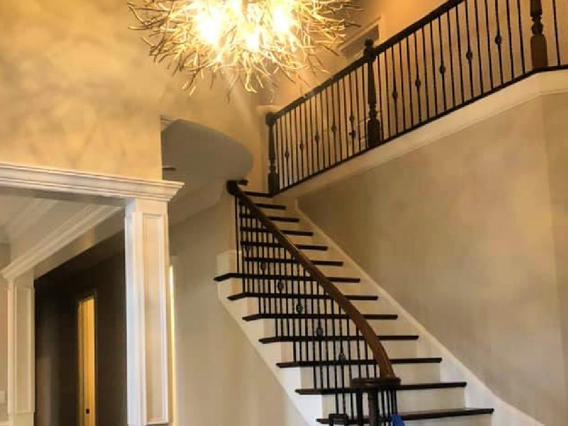 Freshly painted two-story foyer with curved staircase by SouthEnd Painting in Charlotte